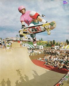 a man flying through the air while riding a skateboard in front of a crowd