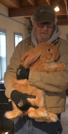 a man holding a rabbit in his arms