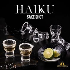 three shot glasses filled with liquid and limes on a black surface next to the words haiku sake shot