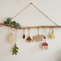 a wall hanging with various wooden animals and plants on it's sides, along with other decorations