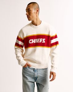 NFL Kansas City Chiefs sweater in our soft sweater-knit fabric and oversized-fit silhouette, featuring a slightly cropped body length, Kansas City Chiefs script graphic logo detail at chest, arm band details, crew neckline and banded hem and cuffs. Nfl Kansas City Chiefs, Men's Tops, Graphic Logo, Soft Sweater, Abercrombie And Fitch, New York Jets, Softest Sweater, Kansas City Chiefs, Sweater Knit