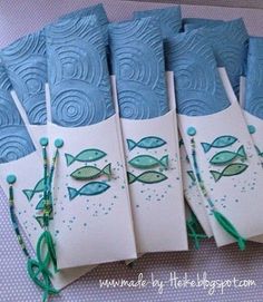 five cards with fish on them sitting next to each other in blue and white paper