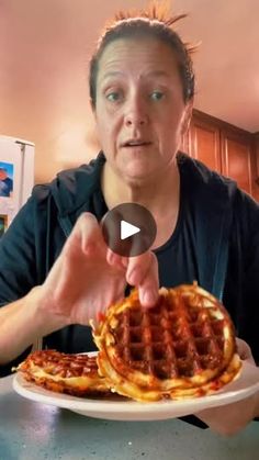 a man holding a plate with waffles on it