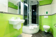 a bathroom with green and white tiles on the walls