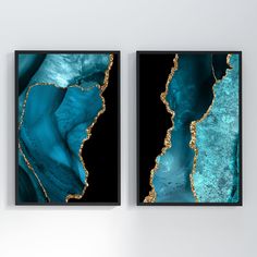 two abstract paintings on the wall with blue and gold paint, each one being framed in black