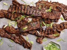 grilled steaks with scallions and green onions on a sheet of parchment paper