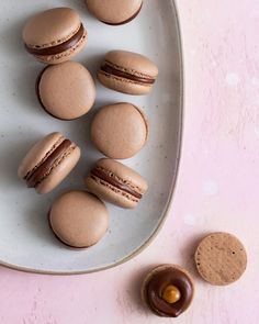 macaroons are arranged on a plate next to an empty chocolate cupcakes