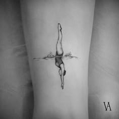 a black and white photo of a woman's leg with a tattoo on it