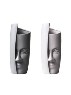 two gray and white vases with faces on them, one in the shape of a human head