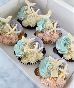 cupcakes decorated with seashells and pearls in a box