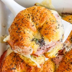 ham and cheese sliders in a white casserole dish with poppy seed sprinkles