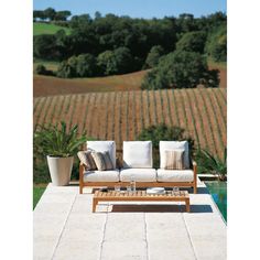 a couch sitting on top of a white tiled floor next to a lush green hillside