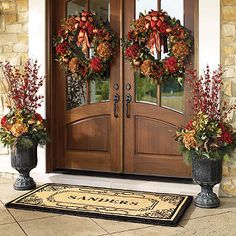 two large wreaths are on the front door