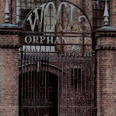 an old brick building with iron gates and the words wolf's orphanage on it