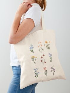 a woman carrying a tote bag with flowers on it