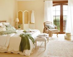 a bedroom with a large bed and white furniture