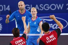 two women and one man are playing tennis