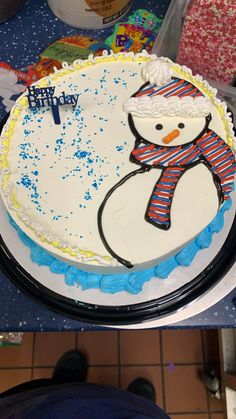 a birthday cake with a frosting snowman on it