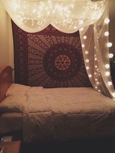 a bed with lights on the ceiling and a tapestry hanging from it's headboard