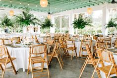 tables and chairs set up for an outdoor wedding reception with palm trees in the background