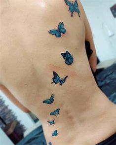 the back of a woman's stomach with blue butterflies on her side and chest