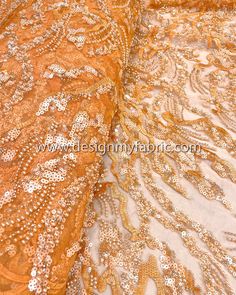 an orange lace fabric with gold sequins