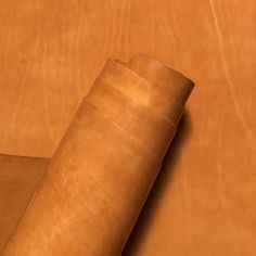 a roll of brown leather sitting on top of a table