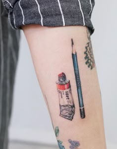 a person with a tattoo on their arm holding a pencil