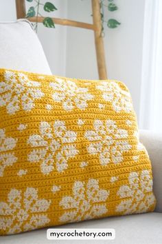 a crocheted pillow sitting on top of a white couch