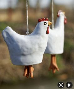 two white ceramic chickens hanging from strings