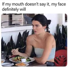 a woman sitting at a table with a plate of food in front of her and the caption if my mouth doesn't say it, my face definitely will