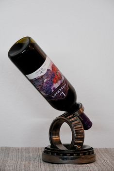 a bottle of wine sitting on top of a metal object with a ring around it