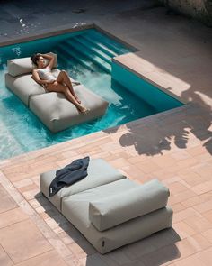 a woman laying on an inflatable couch next to a swimming pool