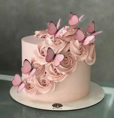 there is a pink cake with butterflies on the top and flowers on the bottom that have been made to look like roses