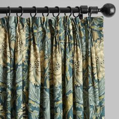 the curtain is closed and ready to be hung in front of an open window with floral curtains