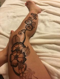 a woman's legs with an intricate tattoo design on the bottom half of her leg