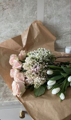 a bouquet of flowers sitting on top of a brown paper bag