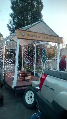 a truck is parked in front of a tent with bubbles hanging from it's roof