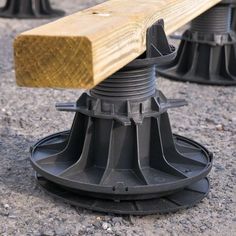 a wooden bench sitting on top of a cement ground next to other metal and wood benches