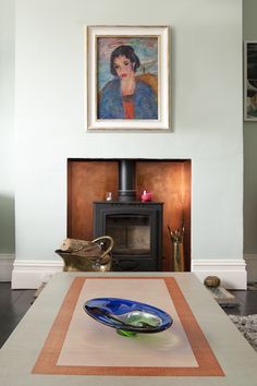 a living room with a painting on the wall and a table in front of it