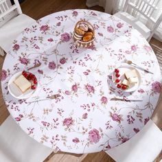 a table topped with plates of food and desserts on top of white cloth covered tables