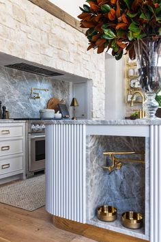 a kitchen with marble counter tops and gold faucets