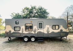 an rv parked on the side of a dirt road