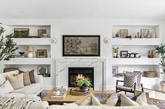 a living room filled with furniture and a fire place in the middle of a room