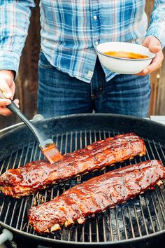 two ribs being grilled on the grill with sauce