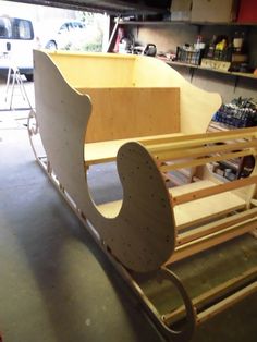 a wooden sleigh is being built in a garage