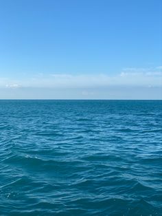 the water is very blue and there are clouds in the sky