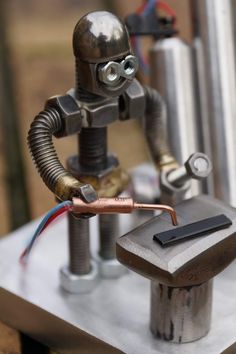 a metal robot with a hammer and some wires