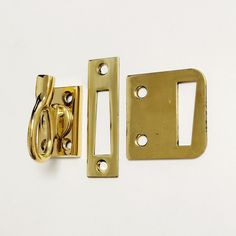 two brass plated latches on white background with clippings for the handles