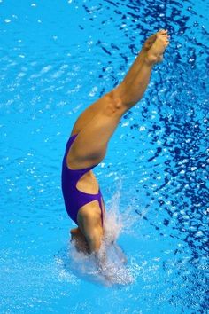 a man in a blue swimsuit is jumping into the water